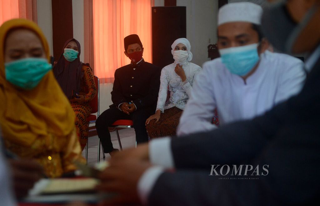 Beberapa pasangan mengikuti nikah massal yang diselenggarakan oleh beberapa lembaga sosial di balai serba guna, Kantor Kecamatan Genuk, Kota Semarang, Jawa Tengah (12/4/2022). Penyelenggaraan pernikahan tersebut untuk membantu warga yang tidak mampu.