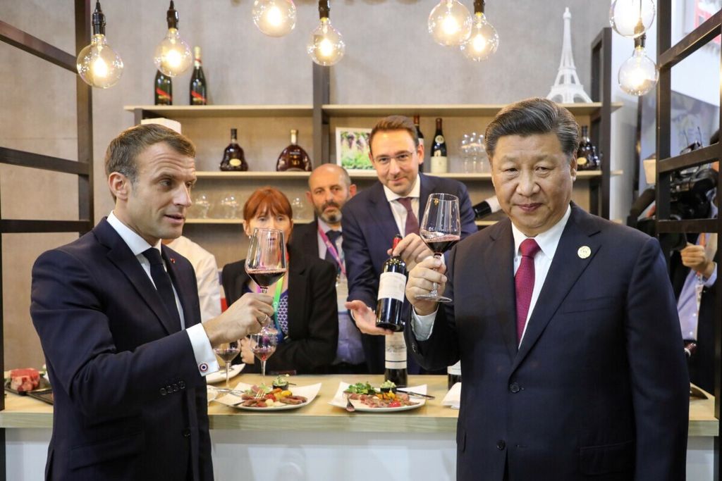 Presiden Perancis Emmanuel Macron (kiri) dan Presiden China Xi Jinping mencicipi minuman anggur saat keduanya mengunjungi paviliun Perancis pada ajang China International Import Expo di Shanghai, China, 5 November 2019. 