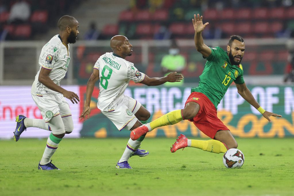 Penyerang Kamerun, Eric Choupa Moting (kanan), ditekel gelandang Komoro, Fouad Bachirou, pada laga babak 16 besar Piala Afrika 2021, Selasa (25/1/2022) dini hari WIB, di Stadion Stadion Paul Biya, Kamerun. Pada laga itu, Kamerun menang 2-1 untuk melanju ke babak perempat final.