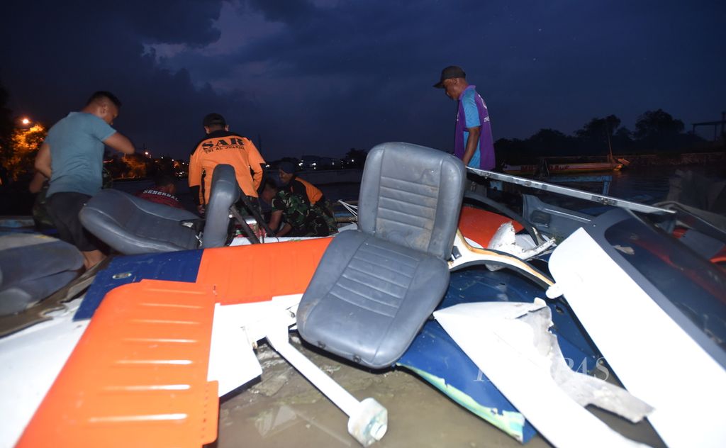 Anggota Pusat Penerbangan TNI AL mengeluarkan dari perahu bagian pesawat latih jenis Tobago T2405 yang mendarat darurat di area tambak Kecamatan Candi, Kabupaten Sidoarjo, Jawa Timur, Selasa (4/2/2020). Pesawat mendarat darurat sore sehari sebelumnya saat mengalami kendala mesin. Dua kru selamat dalam kejadian tersebut. 