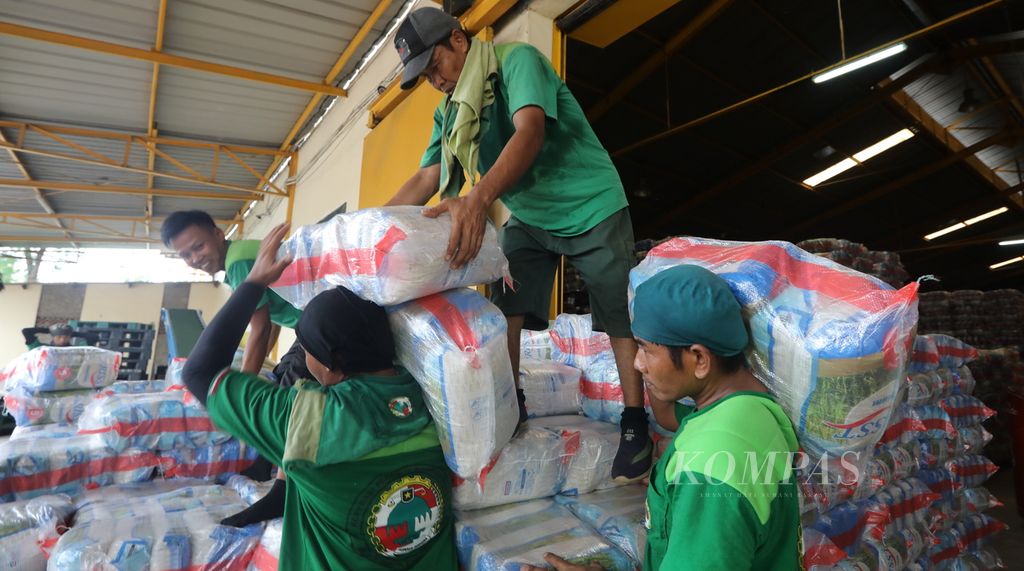 Pekerja memikul karung beras ke truk di gudang PT Food Station Tjipinang Jaya (FSTJ), Cipinang, Jakarta Timur, untuk didistribusikan Rabu (18/3/2020). Stok beras di Pasar Induk Cipinang berada dalam batas aman di kisaran 28.000 hingga 30.000 ton. Adapun stok beras di PT FSTJ sendiri ada cadangan stok 7.000 ton di luar pasar induk Cipinang.