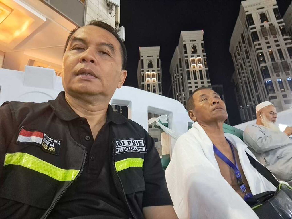 Wartawan <i>Kompas,</i> Adi Prinantyo (kiri), beristirahat sejenak di tengah mengantarkan Asbullah (tengah) menuju hotelnya di kawasan Masjidil Haram, Mekkah, Arab Saudi, pertengahan Juni 2023.