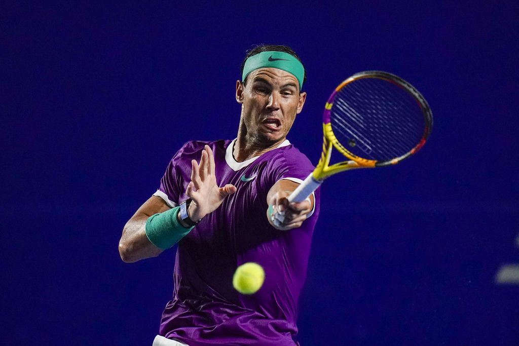 Rafael Nadal memukul bola saat melawan Daniil Medvedev (Rusia) pada laga semifinal turnamen tenis ATP 500 Acapulco di Acapulco, Meksiko, Jumat (25/2/2022). Nadal mengalahkan Medvedev dan berpeluang merebut gelar ketiganya musim ini.