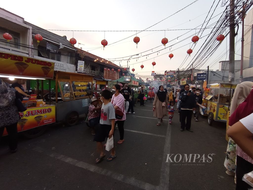 Suasana di pusat kuliner Pasar Lama di Kota Tangerang, Banten, Kamis (14/4/2022). Pedagang kaki lima menempati kiri dan kanan jalan, sedangkan pengunjung dan pengendara berbagi ruang lalu lalang di antara lapak.