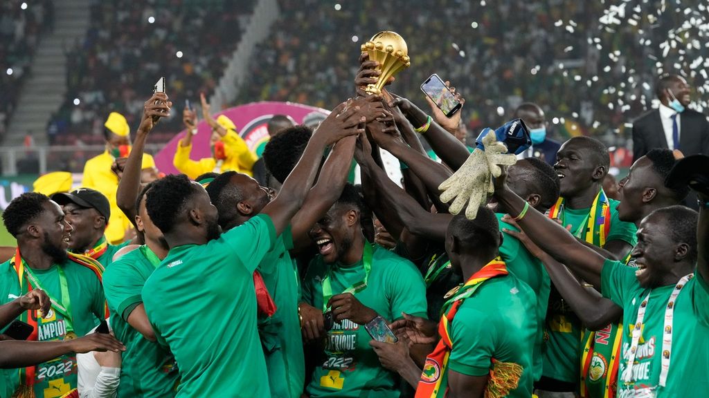 Pemain Senegal mengangkat tropi saat merayakan kemenangan dalam pertandingan final Piala Afrika 2022 melawan Mesir di Stadion Ahmadou Ahidjo di Yaounde, Kamerun, Minggu (6/2/2022). Tim Nasional Senegal memastikan diri menjadi juara Piala Afrika 2021 setelah mengalahkan Mesir di final melalui adu penalti dengan skor 4-2.