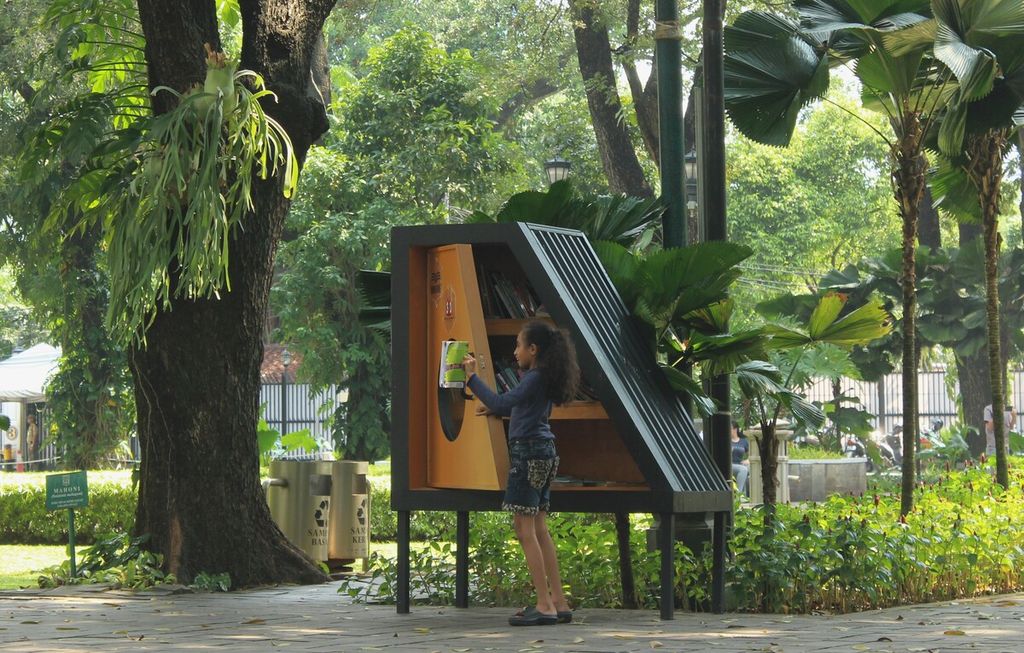 Seorang anak membaca buku yang diambil dari lemari buku Bookhive di Taman Suropati, Menteng, Jakarta Pusat, Senin (24/4/2023). Lemari buku di taman itu mempermudah masyarakat mengakses bahan bacaan sehingga diharapkan meningkatkan literasi.