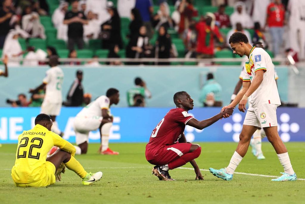 Penyerang Qatar, Almoez Ali (tengah), berjabat tangan dengan penyerang Senegal, Illiman Ndiaye (kanan), setelah berakhirnya pertandingan Grup A Piala Dunia Qatar 2022 antara Qatar dan Senegal di Stadion Al Thumama, Doha, Qatar, Jumat (25/11/2022). Qatar takluk, 1-3. 