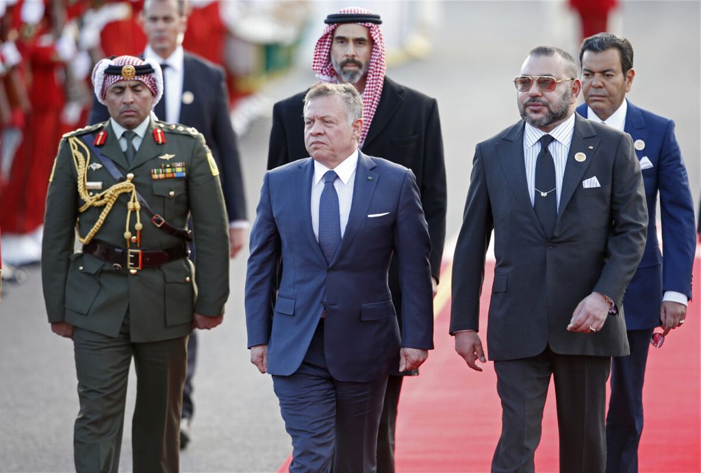 Raja Maroko Mohammed VI (kanan, depan) berjalan dengan Raja Jordania Abdullah II (tengah) dalam upacara memeriksa barisan pasukan kehormatan di istana raja di Rabat, Maroko, 22 Maret 2017. 