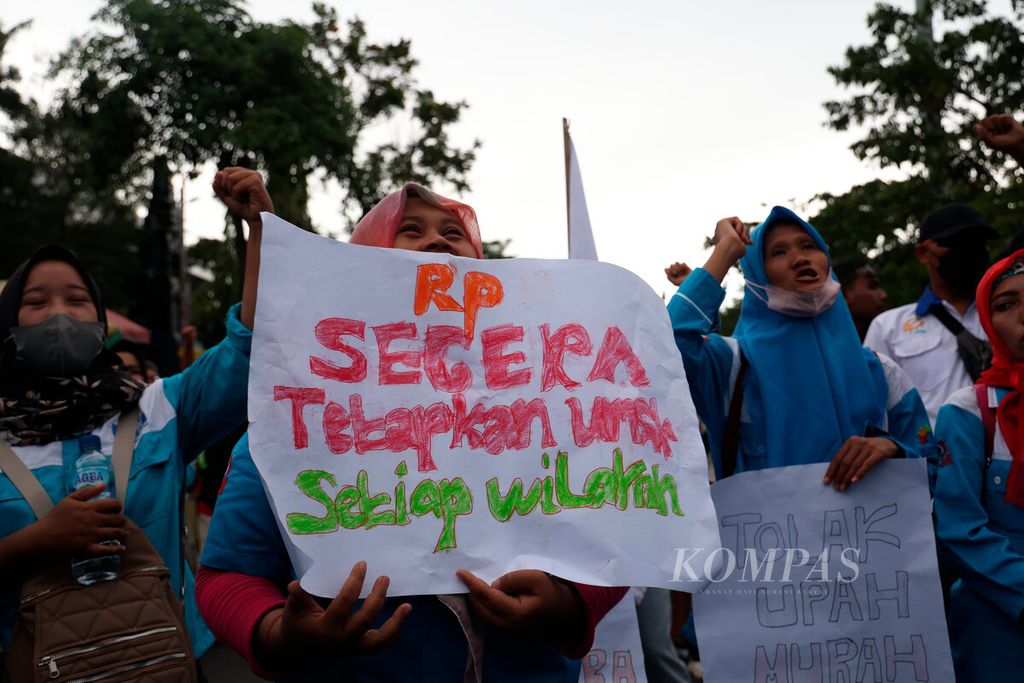 Pekerja membawa poster yang berisi tuntutan kenaikan upah mereka tahun 2024 di Jalan Pahlawan, Kota Semarang, Jawa Tengah, Kamis (30/11/2023). 