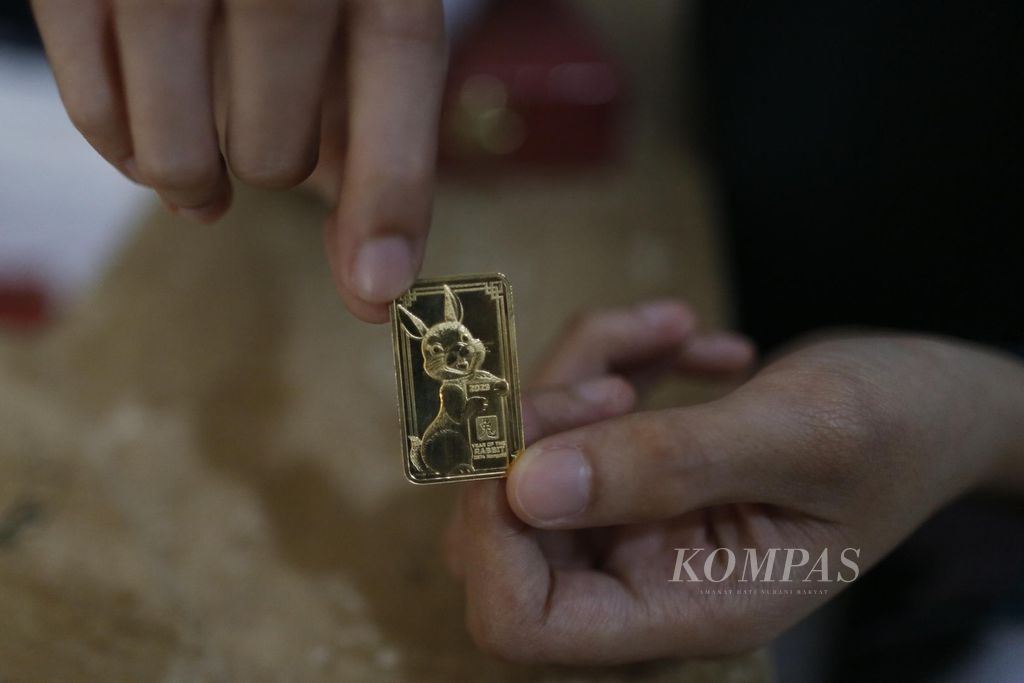 Petugas menunjukkan emas edisi Imlek bergambar kelinci di Butik Emas Antam, Pulo Gadung, Jakarta Timur, Senin (16/1/2023). 