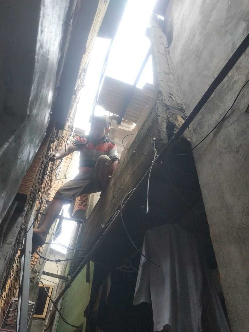 Seorang warga tengah mengecek kondisi lantai dua rumah yang hangus terbakar di kompleks padat penduduk di Kramat Pulo, Senen, Jakarta Pusat, Senin (16/1/2023).