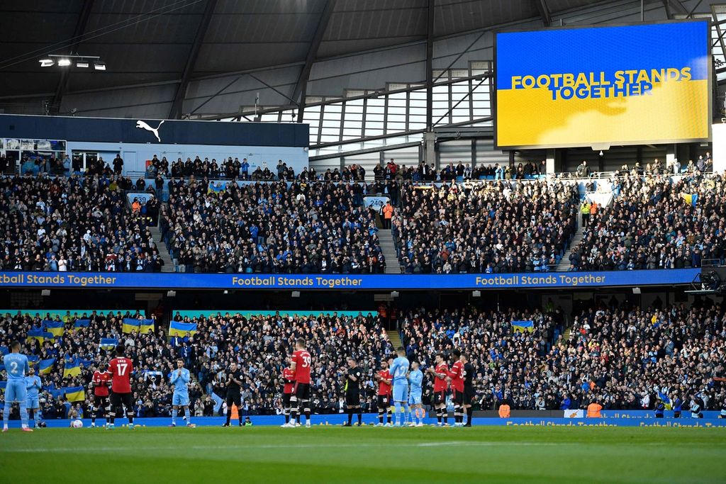 Pemain Manchester City dan Manchester United bertepuk tangan selama semenit sebagai simbol dukungan terhadap Ukraina sebelum pertandingan Liga Inggris antara City dan MU di Stadion Etihad, Manchester, Minggu (6/3/2022). 