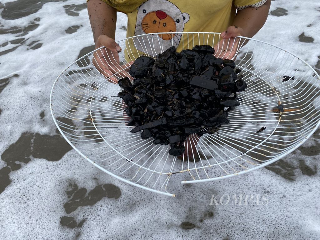 Dengan menggunakan alat sederhana, warga mengumpulkan batubara di pantai Desa Peunaga Rayeuk, Kecamatan Meureubo, Aceh Barat, Minggu (15/10/2023).  
