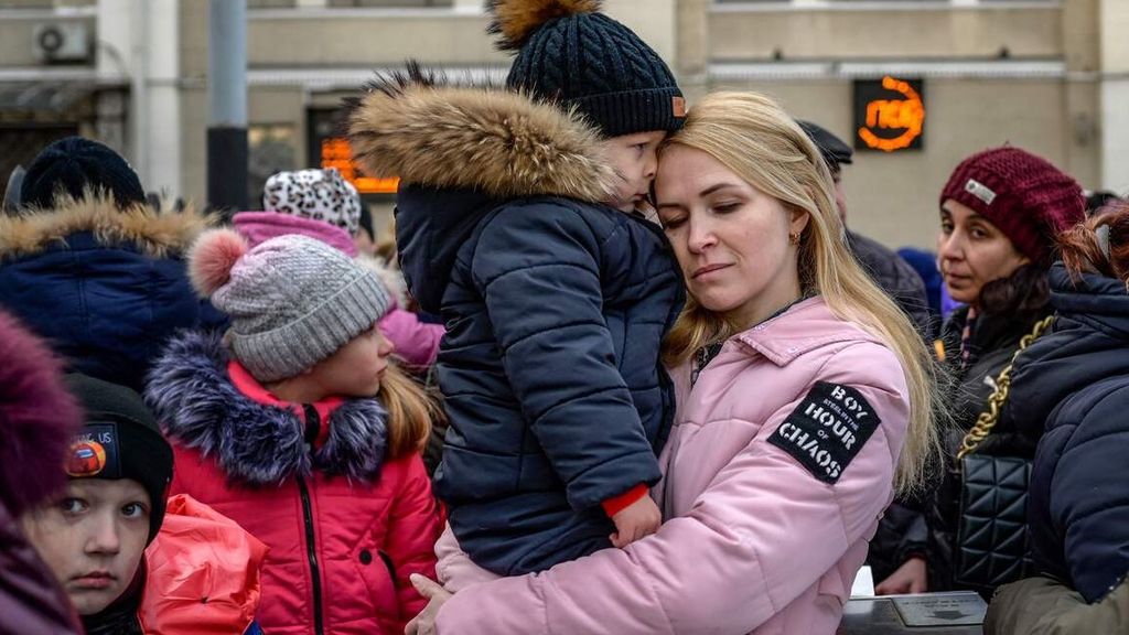 Seorang perempuan memeluk seorang anak saat menanti di stasiun utama kereta di kota pelabuhan Odessa, Ukraina, Rabu (9/3/2022), untuk mengungsi. 