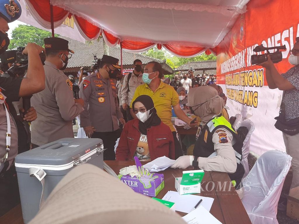 Kapolri Jenderal (Pol) Listyo Sigit Prabowo (berseragam, bertopi, kedua dari kiri) mengecek pelaksanaan vaksinasi serentak dan berdialog dengan warga peserta vaksinasi di Taman Wisata Candi Borobudur, Kabupaten Magelang, Jawa Tengah, Jumat (18/2/2022).