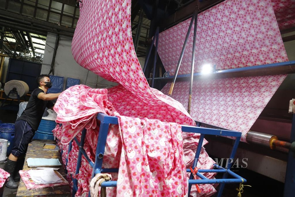 Pekerja pabrik tekstil PT Bentara Sinar Prima di Dayeuhkolot, Kabupaten Bandung, Jawa Barat, sedang mengecek kain yang sedang diproduksi, Rabu (29/3/2023).