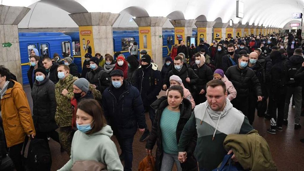 Warga Kiev membawa barang-barang yang dibutuhkan untuk berlindung di stasiun bawah tanah Kiev, Ukraina, 24 Februari 2022.  