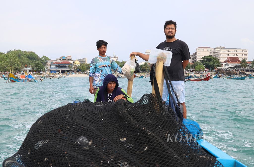 Para pekerja menaiki perahu menuju keramba jaring apung (KJA) di laut lepas Pantai Pangandaran, Kabupaten Pangandaran, Jawa Barat, Sabtu (27/6/2023).