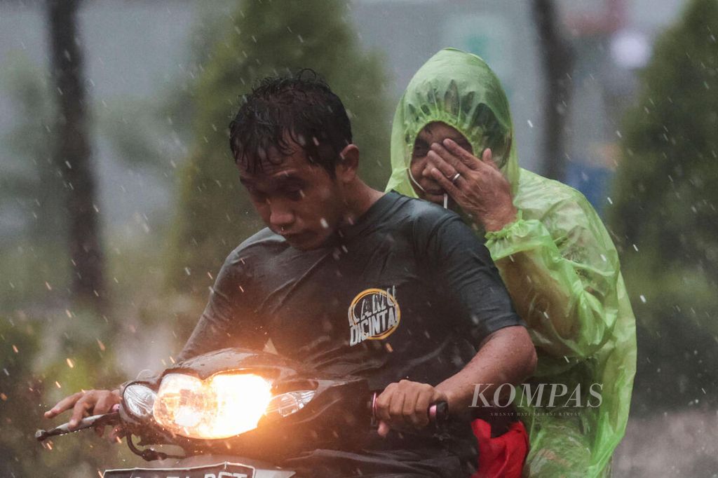 Pengendara sepeda motor menembus hujan deras yang mengguyur kawasan Cianter, Tangerang Selatan, Banten, Minggu (26/3/2023). 