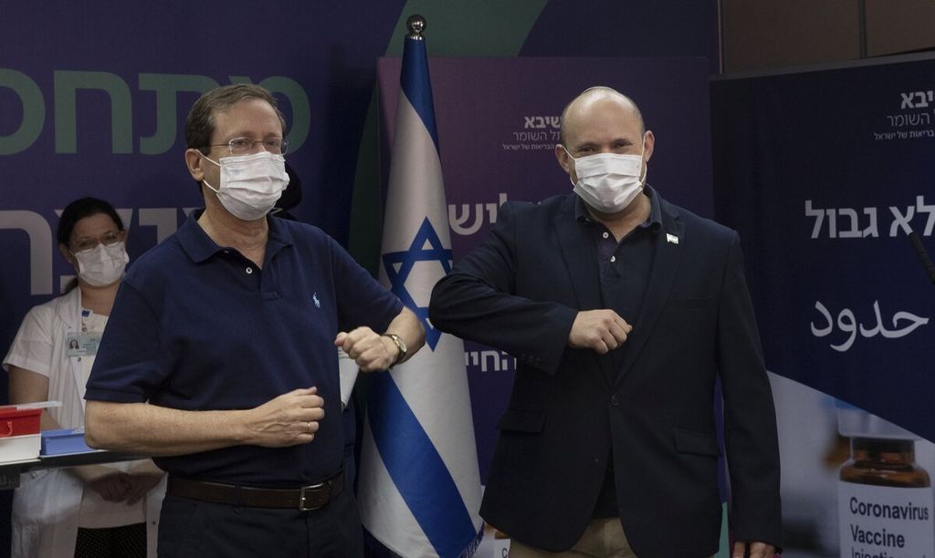  Presiden Israel Isaac Herzog (kiri) dan Perdana Menteri Naftali Bennett bersalaman menggunakan siku setelah menerima suntikan ketiga vaksin Covid-19 di Sheba Medical Center di Ramat Gan, Israel, Jumat (30/7/2021). Keputusan pemberian vaksin ketiga itu diumumkan pada Kamis oleh perdana menteri Naftali Bennet, menjadikan Israel negara pertama yang memberikan dosis ketiga atau booster vaksin Covid-19 kepada warganya dalam skala luas. AP PHOTO/POOL/MAYA ALLERUZZO 