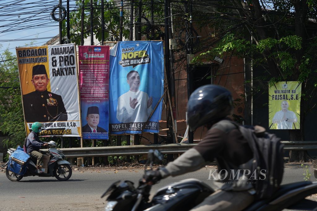 Warga melintasi baliho bakal calon wali kota Kota Bekasi di Rawalumbu, Kota Bekasi, Jawa Barat, Rabu (11/9/2024). 