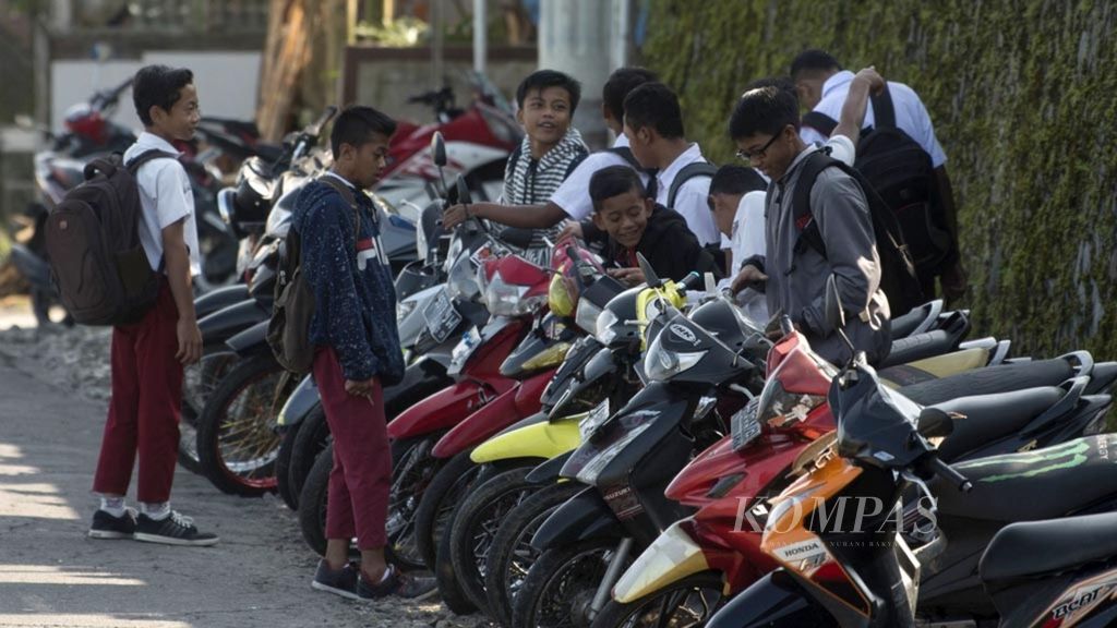 Pelajar SD memarkir sepeda motor yang mereka kendarai ke sekolah di Desa Sobowono, Pakis, Magelang, Jawa Tengah, Senin (13/5/2019).