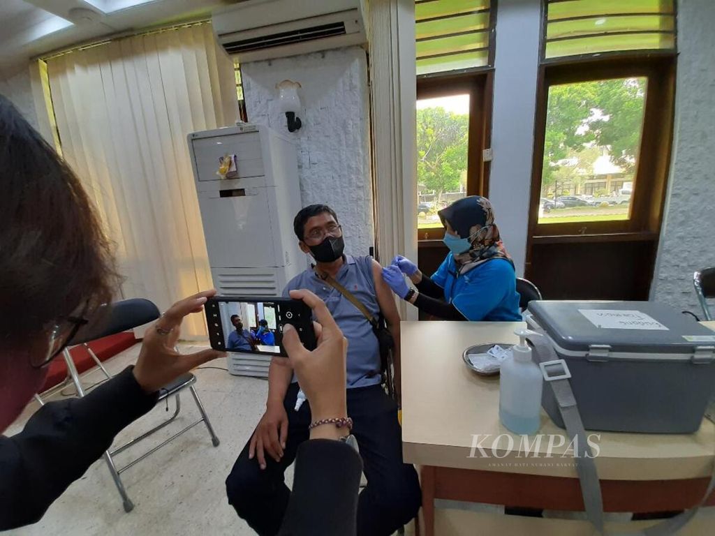 Seorang jurnalis memotret salah seorang rekan wartawan yang mendapatkan vaksinasi dosis penguat di Kantor Pemerintah Kota Magelang, Jawa Tengah, Rabu (19/1/2022).