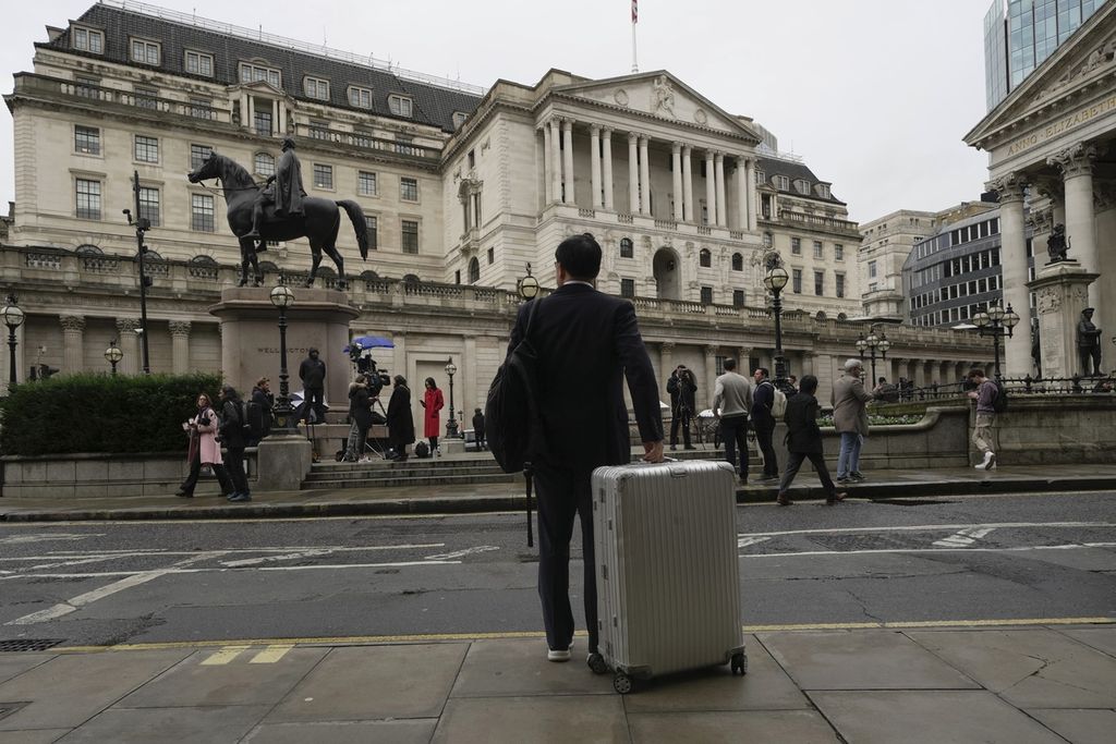 Seorang pria dengan membawa sebuah koper berdiri di depan kantor Bank Inggris di pusat keuangan di London, Inggris, 3 November 2022. 