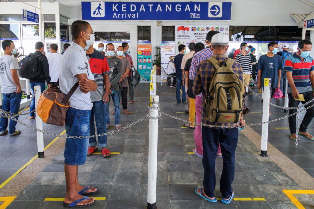 Indonesian migrant workers maintain physical distance while queuing for their health and immigration check on Thursday (21/5/2020) at the Batam Center International Ferry Port in Batam, the Riau Islands. Afterwards, the workers were placed in quarantine at the Tanjung Uncang Dormitory in Batam.