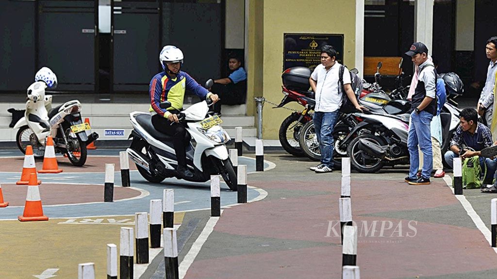 Petugas kepolisian memberikan contoh keterampilan berkendara dalam uji praktik pembuatan surat izin mengemudi (SIM) C di Kepolisian Resor Depok, Kota Depok, Jawa Barat, Kamis (13/9/2018). 