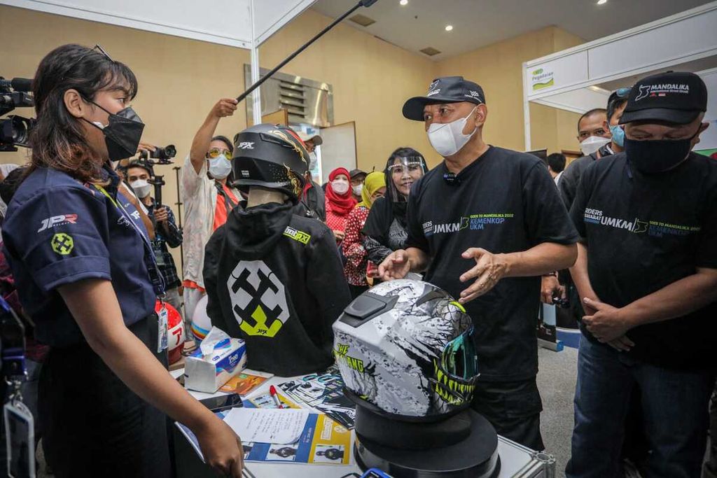 Menteri Koperasi dan UKM Teten Masduki (tengah) berbincang dengan produsen helm yang diperkenalkan dalam ajang "UMKM Goes to Mandalika" di Gedung Smesco, Jakarta, Minggu (6/3/2022).