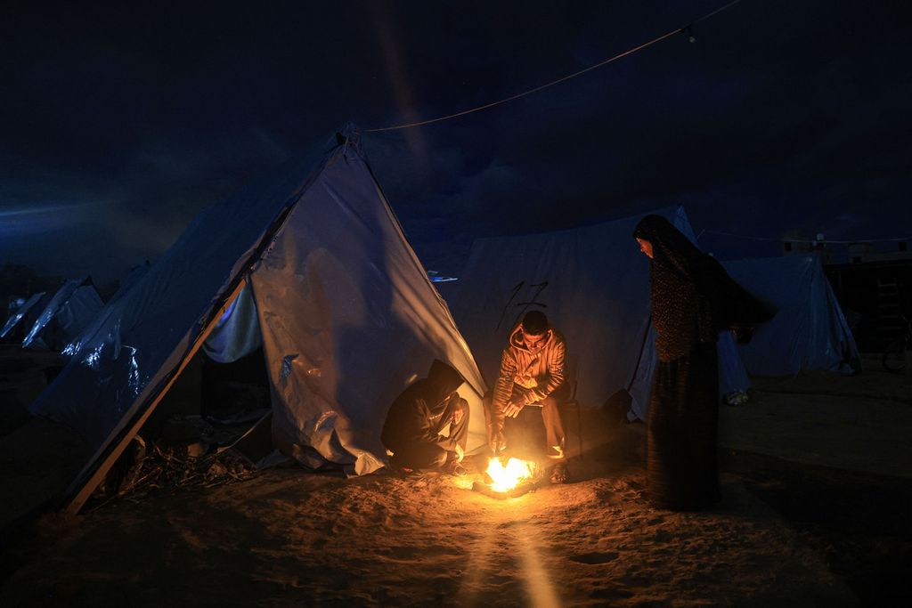 Pengungsi Palestina berkumpul di dekat tenda mereka di Khan Younis dekat pagar perbatasan antara Israel dan Jalur Gaza selatan, 27 November 2023. 
