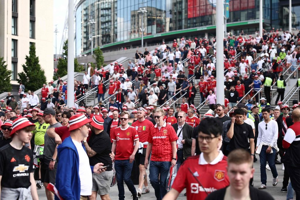 Pendukung Manchester United meninggalkan Stadion Wembley, London, dengan kekecewaan seusai laga final Piala FA, Sabtu (3/6/2023) malam. MU kalah, 1-2.