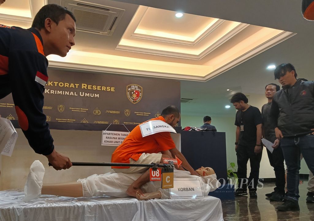 Tersangka M Ecky Listiantho memperagakan adegan ulang mendorong lalu mencekik leher korban Angela hingga meninggal, Rabu (1/3/2023), di ruang Direktorat Reserse Kriminal Umum Polda Metro Jaya.