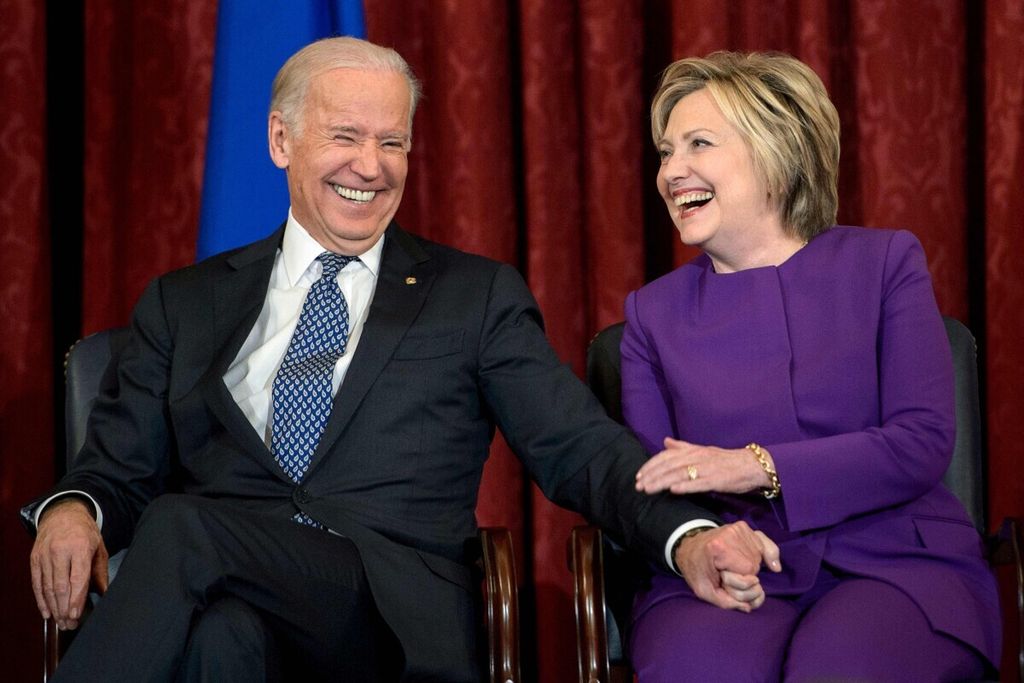 Foto yang diambi per 28 April 2020 ini menampilkan Joe Biden yang saat itu masih menjadi wakik presden Amerika Serikat (kanan) dan Hillary Clinton selaku menteri luar negeri pada suatu kesempatan di di Capitol Hill per 8 Desember 8, 2016 di Washington, DC. –  (Photo by Brendan Smialowski / AFP)