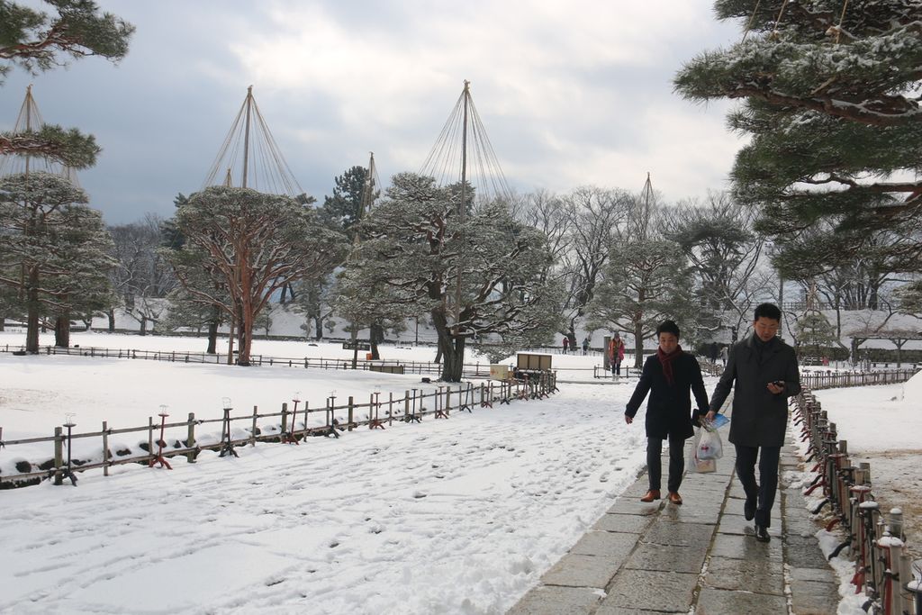 Pengunjung berjalan di lintasan jalan yang bersalju di Kota Aizu, Prefektur Fukuhsima, Jepang, awal Februari 2019.