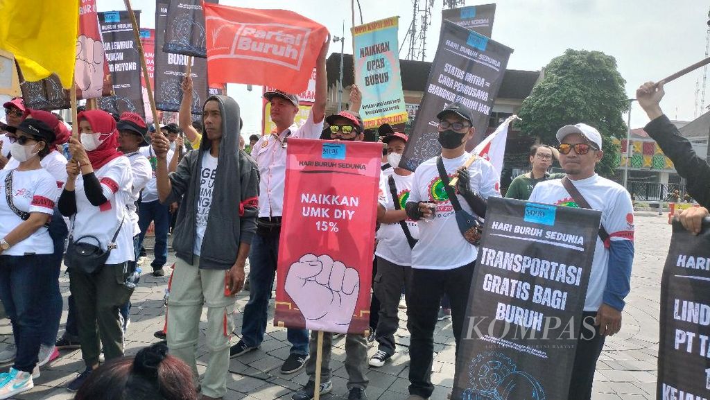 Ratusan buruh mengangkat papan, lembaran kertas, dan karton berisi beragam tuntutan dalam aksi memperingati Hari Buruh di Tugu Yogyakarta, Kota Yogyakarta, Rabu (1/5/2024).