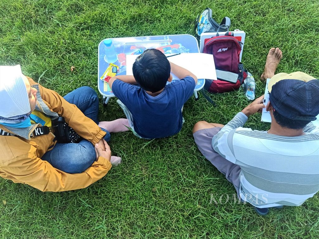 Pasangan orangtua mendampingi putranya yang terlibat dalam acara Gembira Menggambar di Alun-alun Purworejo, Jawa Tengah, Minggu (21/5/2023). Selain mendampingi, ayah si anak juga mencoba ikut terlibat berkarya.