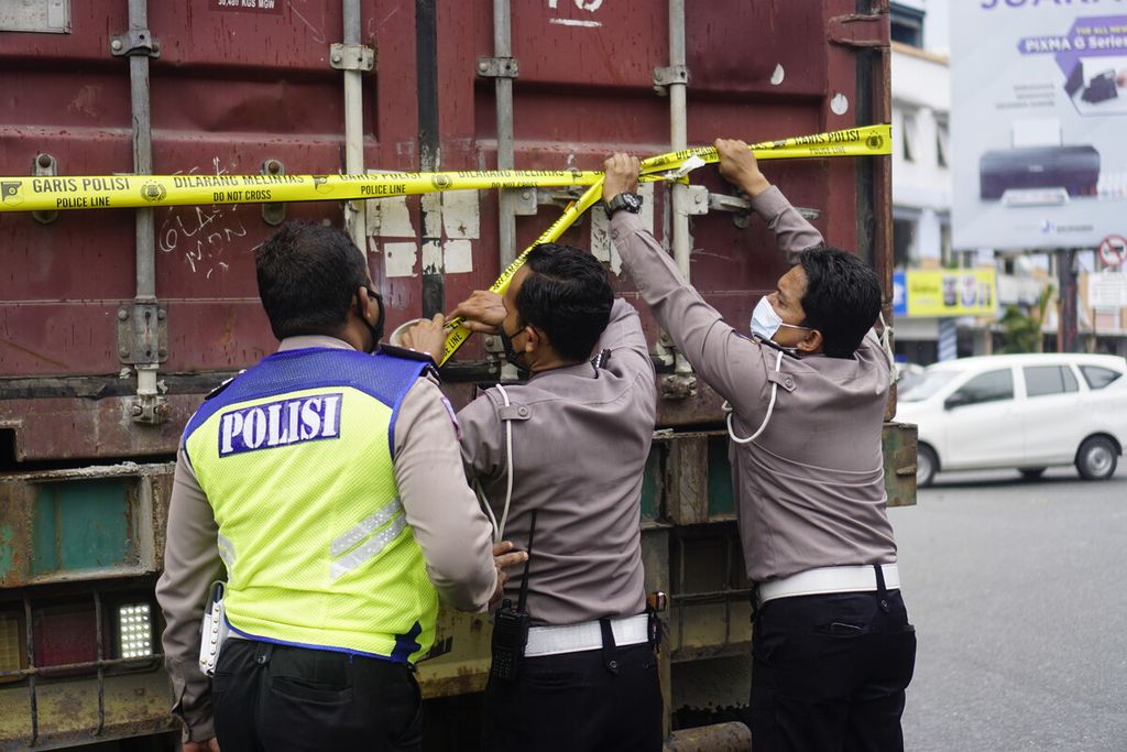Polisi memasang garis polisi pada truk kontainer yang menabrak belasan kendaraan dalam kecelakaan di simpang Muara Rapak, Kecamatan Balikpapan Utara, Kota Balikpapan, Kalimantan Timur, Jumat (21/1/2022). Sebanyak 4 orang meninggal, 4 luka parah, dan 26 luka ringan.