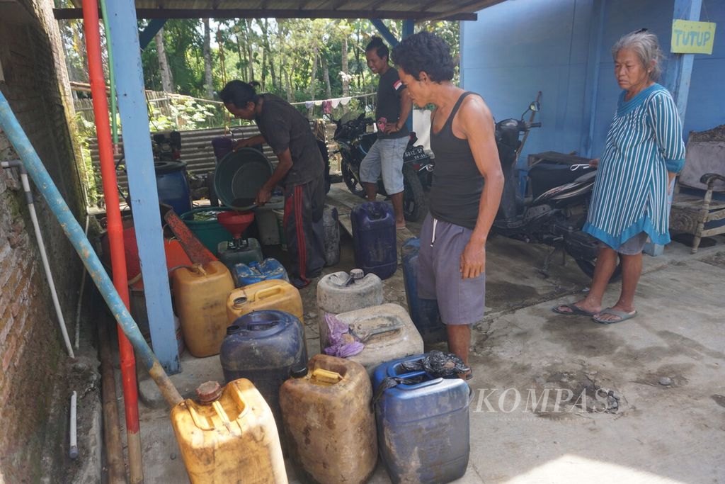 Warga Jalan Melon mengumpulkan sisa-sisa solar yang tumpah dari kebocoran pipa Pertamina di Jeruklegi, Cilacap, Jawa Tengah, Sabtu (6/8/2022).