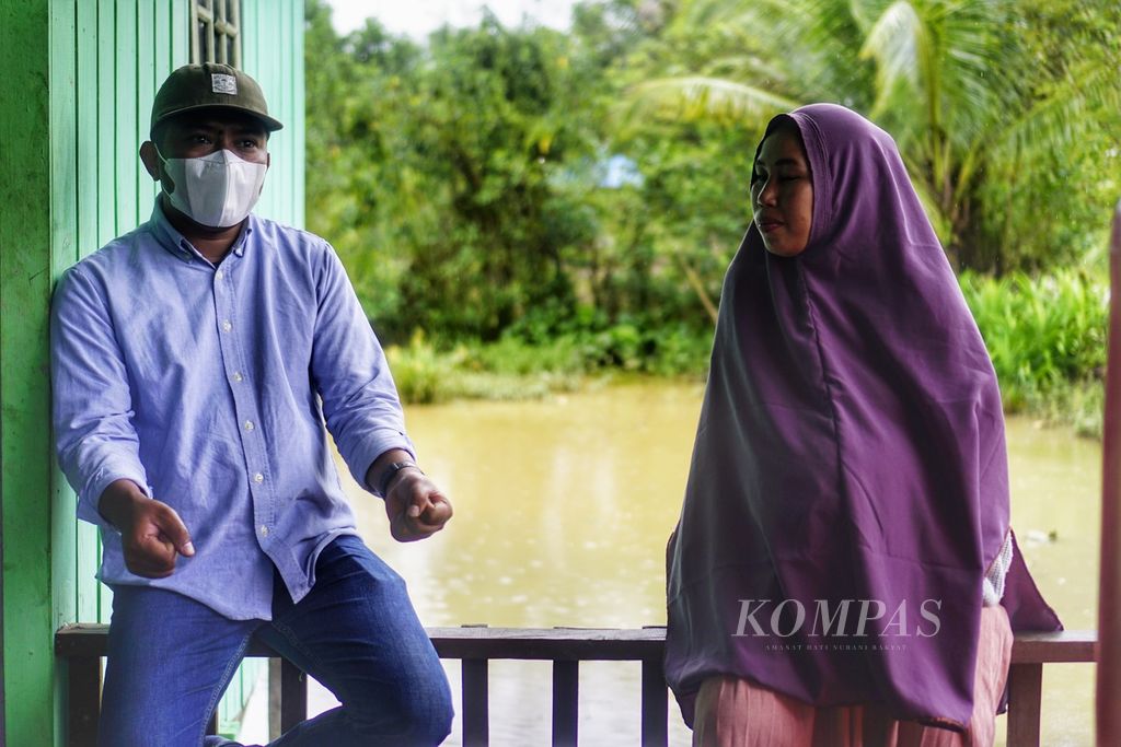 Yati Dahlia (31) berbincang dengan kontributor Kompas.com, Zakarias Demon Daton, di halaman rumahnya di Desa Bumi Harapan, Kecamatan Sepaku, Penajam Paser Utara, Kalimantan Timur, Minggu (20/3/2022).