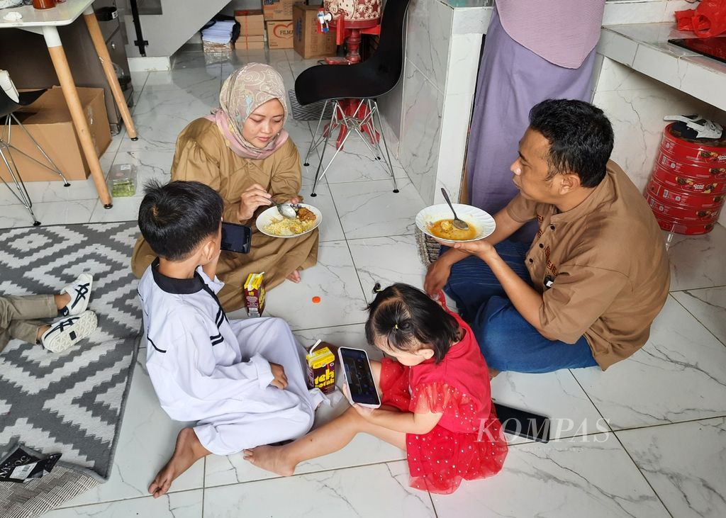 Warga menyantap makanan saat berkunjung ke rumah keluarga pada hari pertama Idul Fitri 1443 Hijriah di Petamburan, Jakarta Pusat, Senin (2/5/2022). 