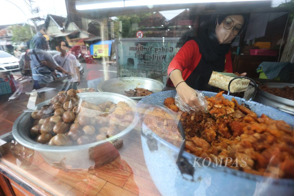 Penjual gudeg melayani pembeli di sentra pedagang makanan gudeg di kawasan Wijilan, Yogyakarta, Selasa (27/12/2022). 