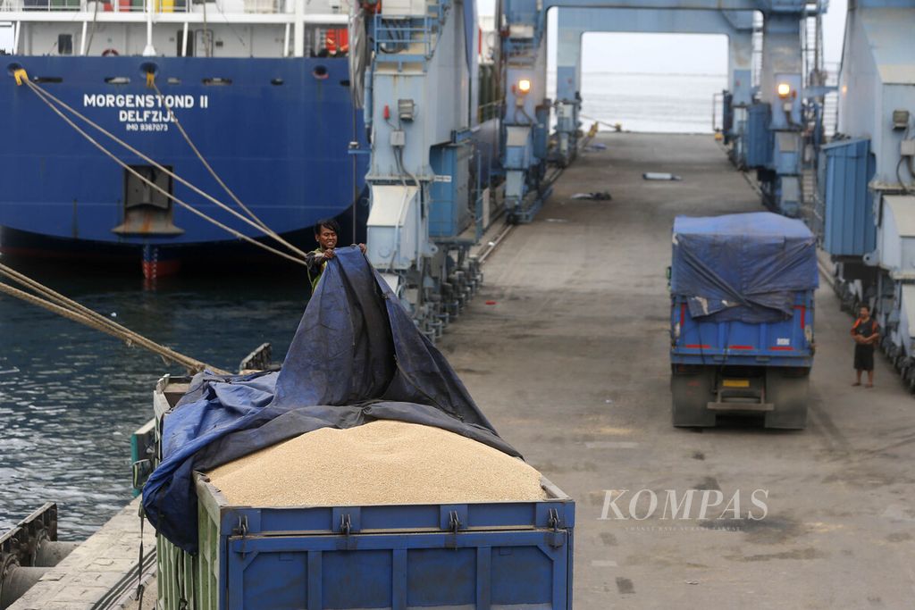 Pekerja menggunakan terpal untuk menutup bak truk berisi gandum yang didatangkan dari Australia di Pelabuhan Tanjung Priok, Jakarta Utara, Selasa (20/12/2022). 