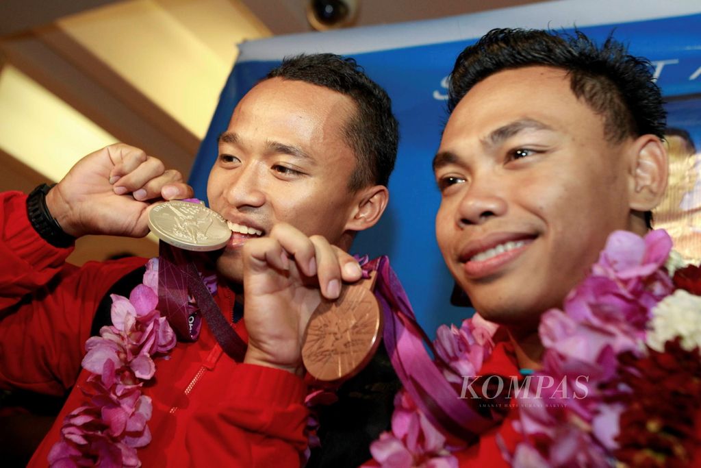 Lifter putra Indonesia, Triyatno (kiri) dan Eko Yuli Irawan, tiba di Bandara Soekarno-Hatta, Banten, Sabtu (4/8/12). Triyatno mempersembahkan medali perak kelas 69 kilogram, sedangkan Eko meraih medali perunggu kelas 62 kilogram dalam ajang Olimpiade 2012 di London.