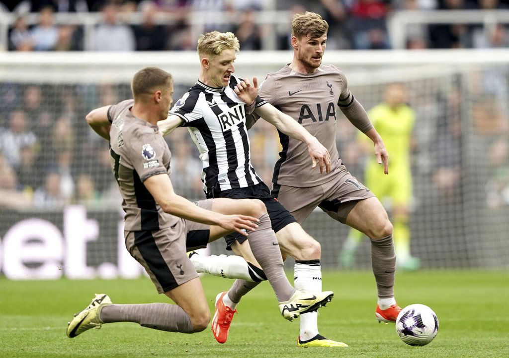 Pemain Tottenham Hotspur, Micky van de Ven (kiri), berebut bola dengan pemain Newcastle United Anthony Gordon (tengah) pada laga Liga Inggris di Stadion St James' Park, Newcastle, Sabtu (13/4/2024). Newcastle menang 4-0 pada laga itu