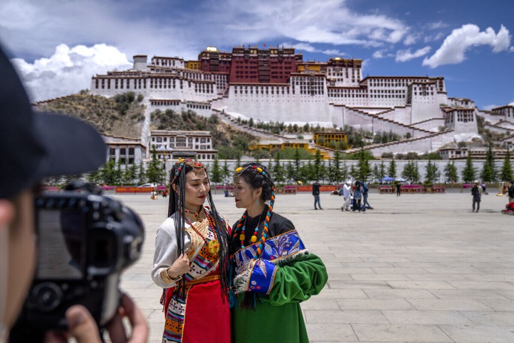Turis asal China berpakaian Tibet berpose di alun-alun dekat Istana Potala di Lhasa di Daerah Otonomi Tibet, China barat, 1 Juni 2021.  