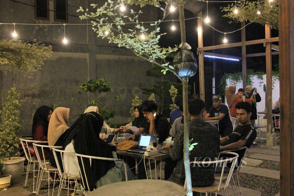 Warga menikmati makanan dan minuman di salah satu cafe konsep terbuka di Kota Banda Aceh, Provinsi Aceh, Jumat (24/2/2023). Budaya ngopi telah mendorong para pebisnis untuk membuat konsep warung/cafe lebih kekinian.