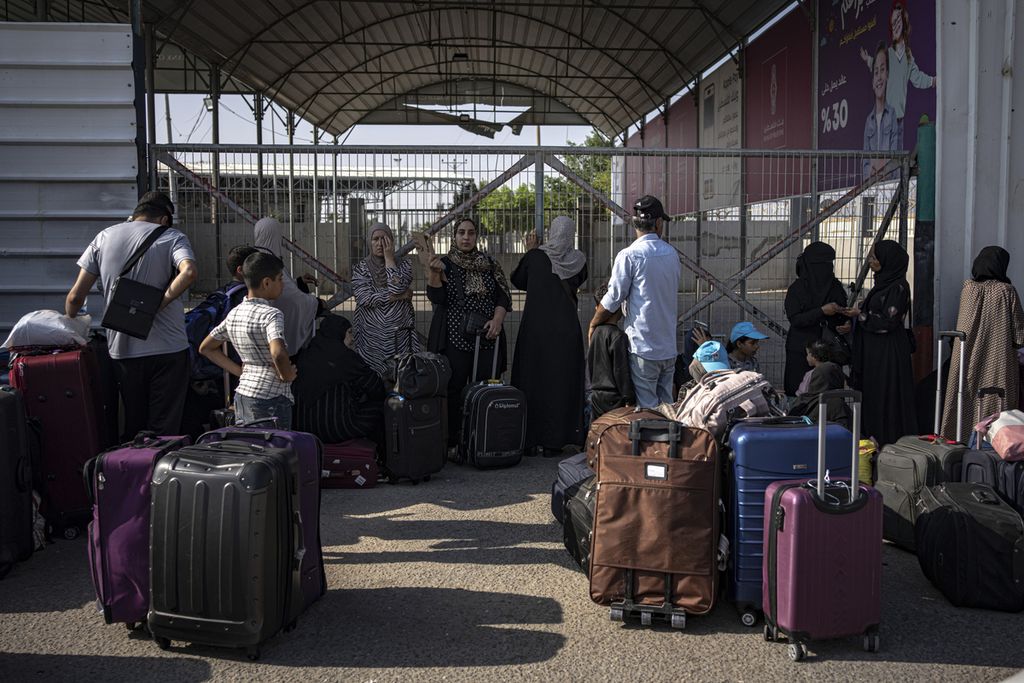 Warga Palestina menunggu di pintu Perbatasan Rafah untuk menyeberang ke Mesir, Rabu (1/11/2023).  