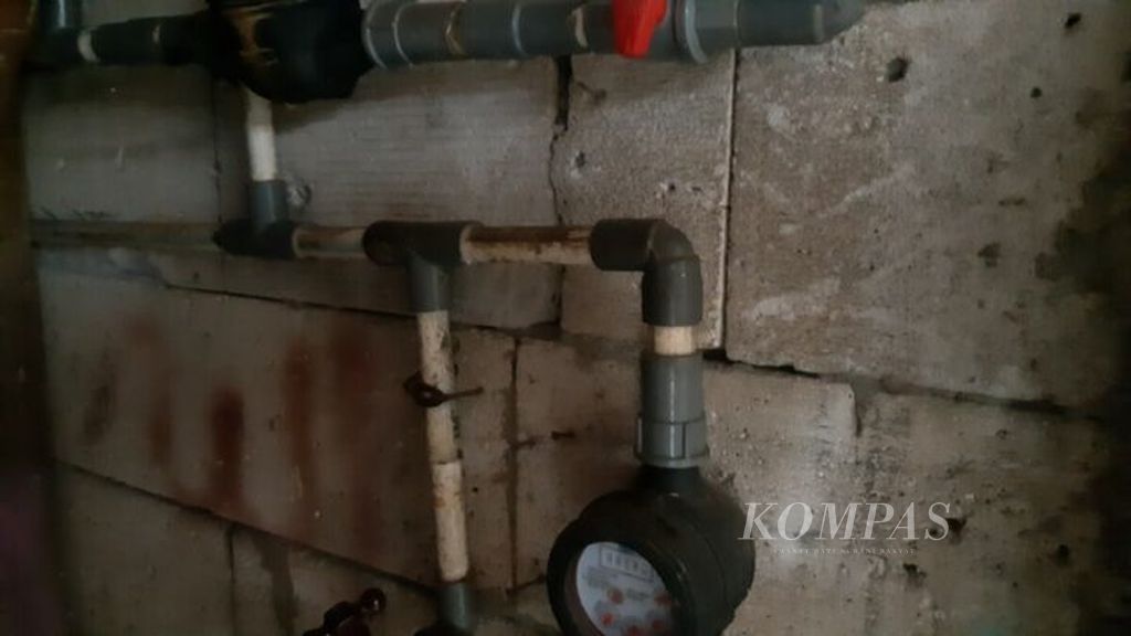 Salah seorang warga Rawa Elok, Jakarta Utara, menunjukkan dua meteran air miliknya, Kamis (10/6/2021). Meteran air itu dipasang oleh Wy, salah seorang pedagang air di tempat itu.